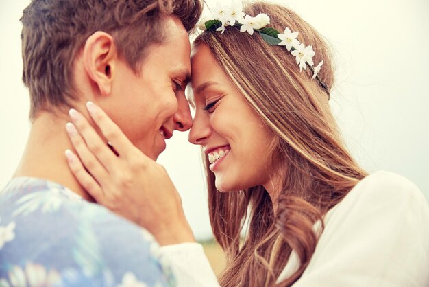 vacaciones de verano, amor, romance y concepto de la gente - feliz sonriente joven pareja hippie abrazándose al aire libre