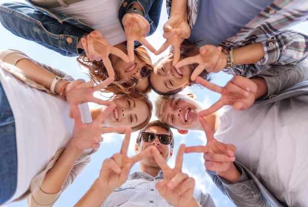 vacaciones de verano y concepto adolescente - grupo de adolescentes mostrando gesto de paz o victoria