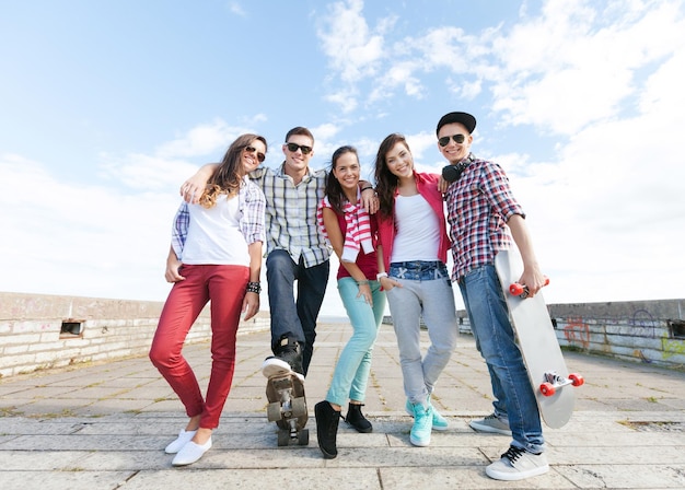 vacaciones de verano y concepto adolescente - grupo de adolescentes con patines fuera