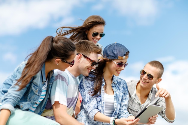 vacaciones de verano, concepto de adolescentes y tecnología - grupo de adolescentes mirando una computadora de tablet pc al aire libre