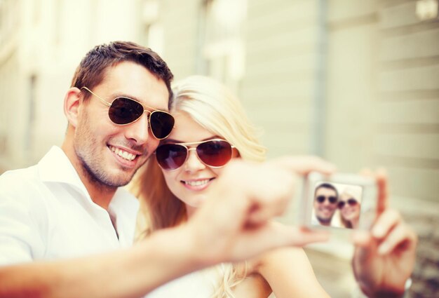 vacaciones de verano y concepto de citas - pareja tomando fotos en un café en la ciudad