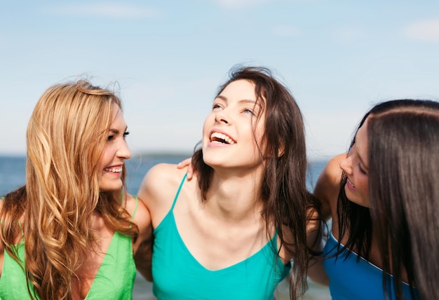 vacaciones de verano y concepto de vacaciones - chicas caminando por la playa