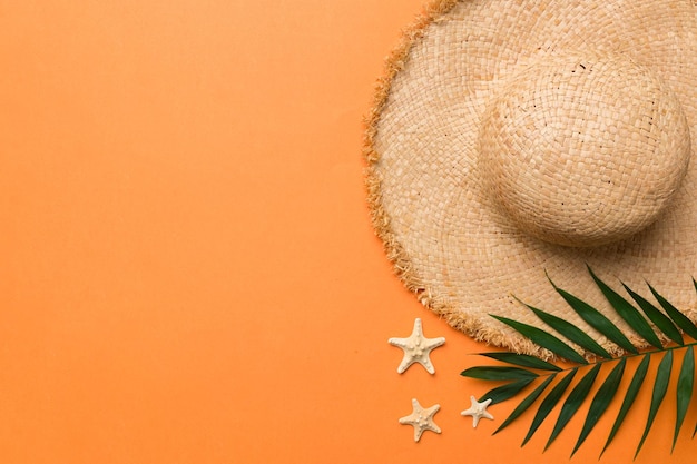 Vacaciones de verano Concepto de verano con sombrero de paja y hoja tropical Espacio de copia de vista superior plana