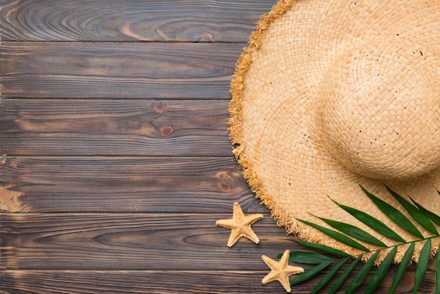 Vacaciones de verano Concepto de verano con sombrero de paja y hoja tropical Espacio de copia de vista superior plana