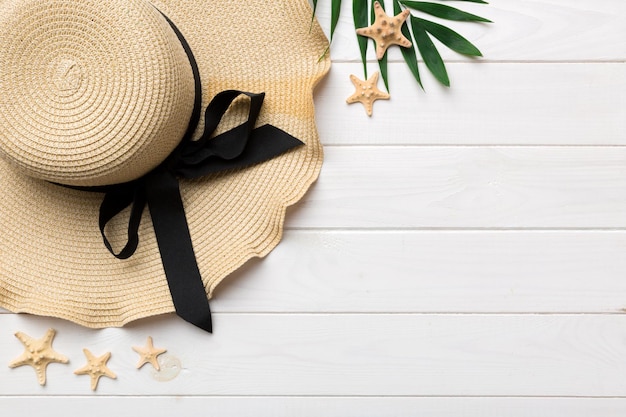 Vacaciones de verano Concepto de verano con sombrero de paja y hoja tropical Espacio de copia de vista superior plana