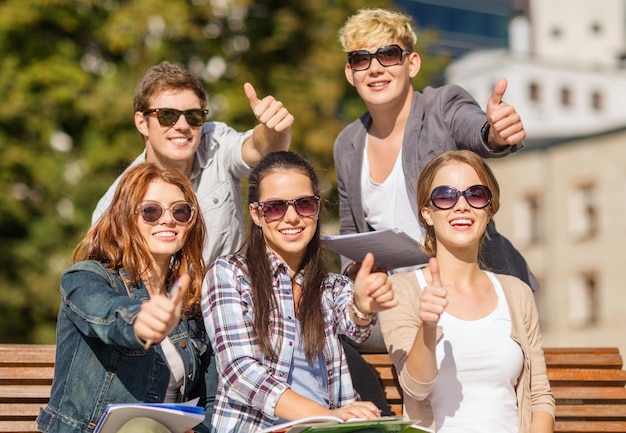 vacaciones de verano, educación, campus y concepto adolescente - grupo de estudiantes o adolescentes con libros, cuadernos, archivos y carpetas