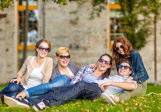 vacaciones de verano, educación, campus y concepto adolescente - grupo de estudiantes o adolescentes que pasan el rato al aire libre