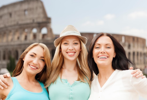 vacaciones de verano, gente, viajes, turismo y concepto de vacaciones - grupo de mujeres jóvenes sonrientes sobre el coliseo en el fondo de roma