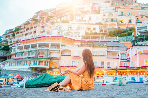 Vacaciones de verano en Italia. Mujer joven en la aldea de Positano en el fondo, costa de Amalfi, Italia