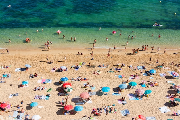 Vacaciones de verano en portugal. Multitud de bañistas en la playa de Benagil en el Algarve