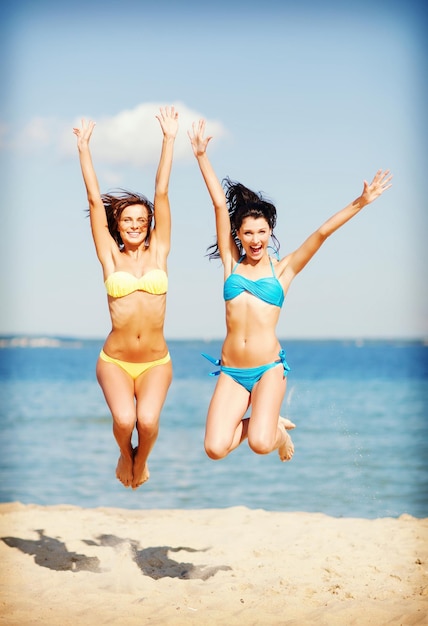 vacaciones de verano y vacaciones - chicas saltando en la playa