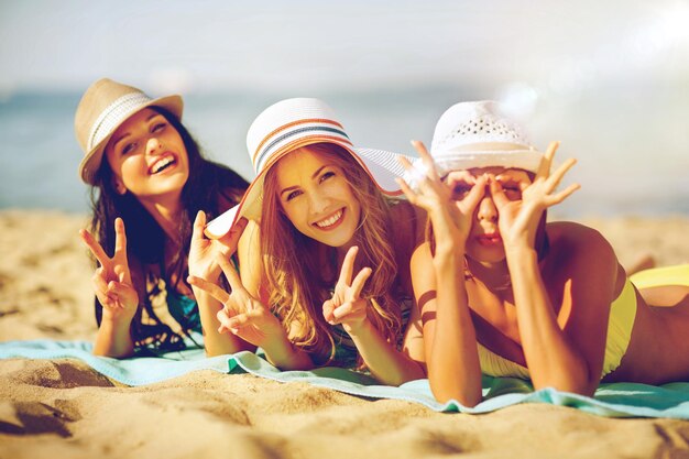 Vacaciones de verano y vacaciones - chicas tomando el sol en la playa