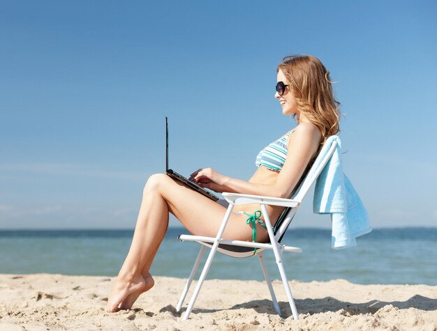 vacaciones de verano, vacaciones, tecnología e internet - chica mirando tablet pc en la silla de playa