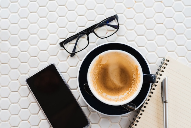 Vaciar una taza de café en mesa blanca