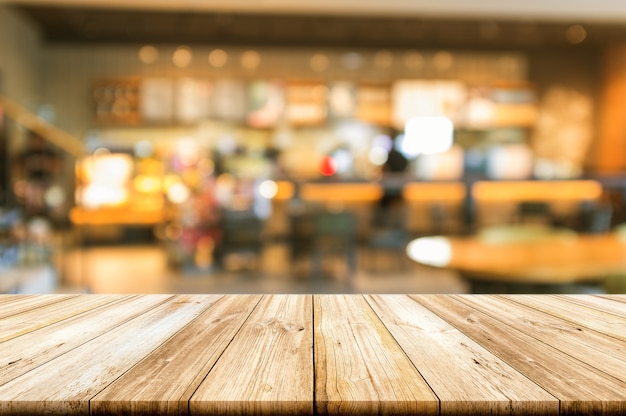 Vacie la sobremesa de madera con el fondo interior borroso de la cafetería.