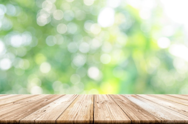 Vacie la sobremesa de madera con el fondo verde borroso del jardín.