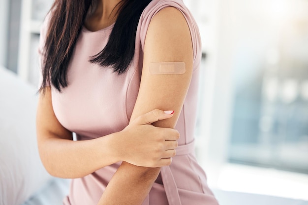 Foto vacina covid e curativo no braço da mulher no hospital para bem-estar médico e medicina injeção de vírus de saúde e gripe com paciente menina e gesso para primeiros socorros doentes ou tratamento na clínica