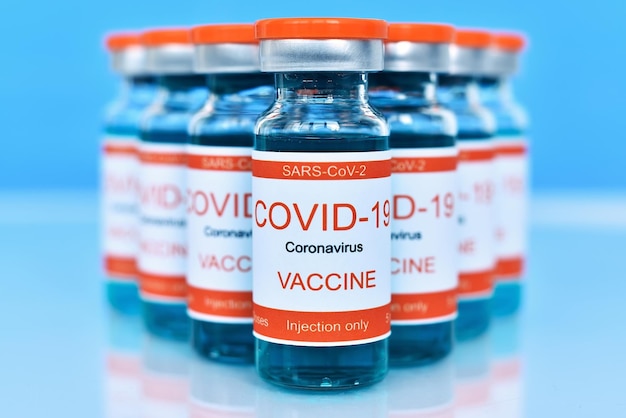 Vacina covid19 em garrafas na mesa azul