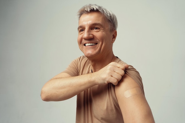 Foto vacinação de vacinação de homem grisalho velhice contra a epidemia um paciente satisfeito