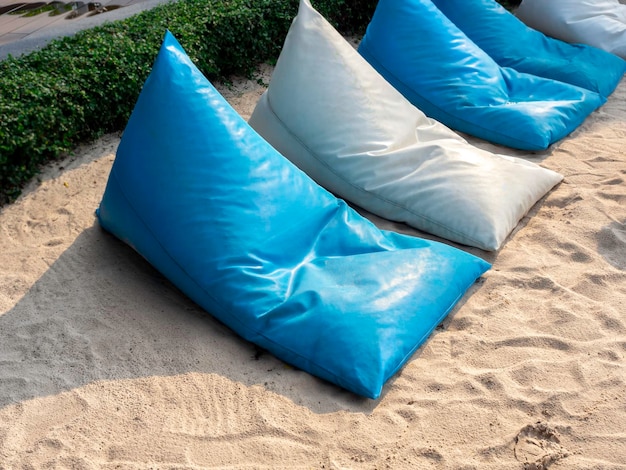 Vacío moderno azul y blanco triángulo bean bag asientos almohadas sillas dispuestas en la playa de arena decoración al aire libre