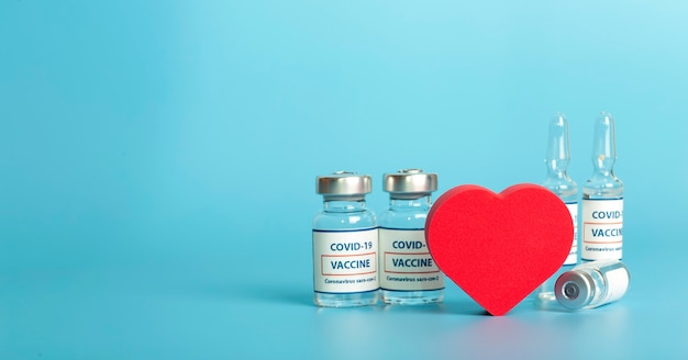 Vacuna contra covid viales médicos de vidrio con ampolla líquida con vacuna contra coronavirus y corazón en ...