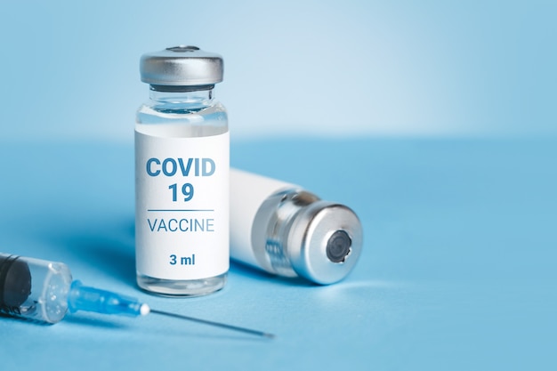 Vacuna para el coronavirus. Ampollas con vacuna contra coronavirus y jeringa. Tratamiento para el COVID-19. Copia espacio