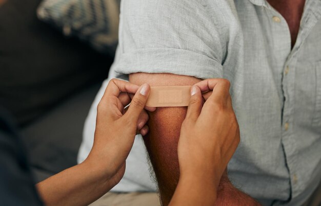 Vacuna covid y yeso con las manos de un médico pegando una tirita a un paciente en el hospital o clínica Medicina sanitaria y confianza con una enfermera que consulta con un hombre por cuestiones de salud