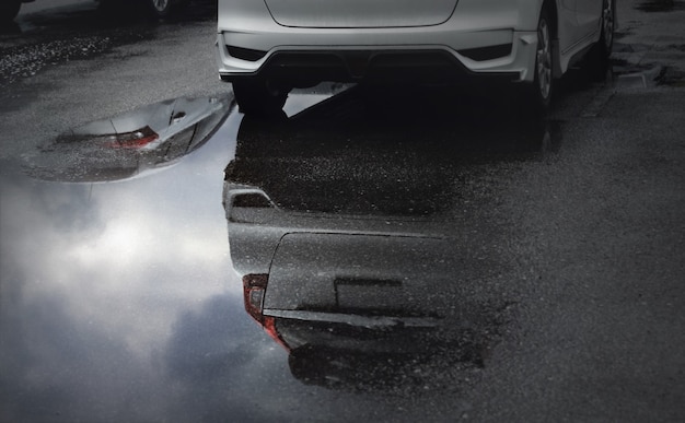 Vagas de estacionamento molhadas após chuva forte caem com reflexo do céu em uma poça no chão. Foco seletivo.