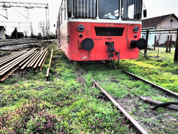 Vagón de tren retro de color rojo Locomotora vintage hecha en Yugoslavia Sremska Mitrovica Serbia El cuerpo metálico de un vehículo ferroviario Rieles oxidados Estación de ferrocarril Carro vacío en un callejón sin salida