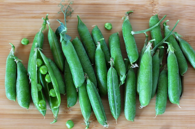 Vainas de guisantes verdes en una tabla de cortar alimentos frescos verduras vista superior