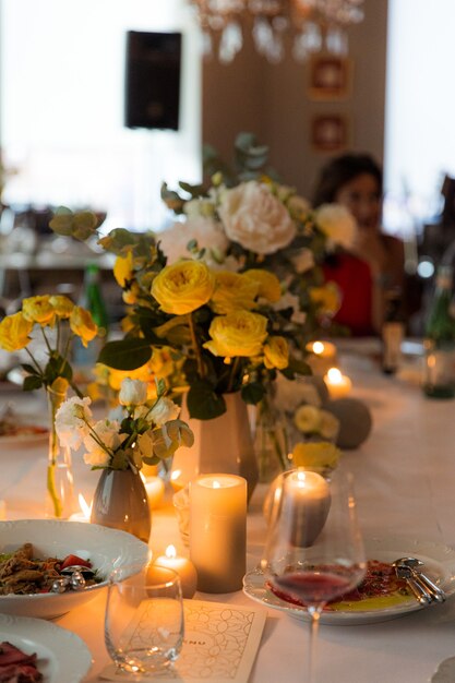 Vajilla con rosas amarillas para una fiesta a la luz de las velas