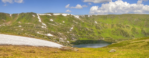 Vale da montanha com lago na primavera