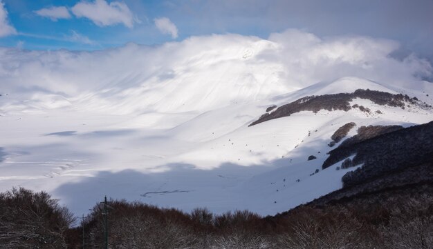 Vale da paisagem de inverno e colinas cobertas de neve em um dia ensolarado