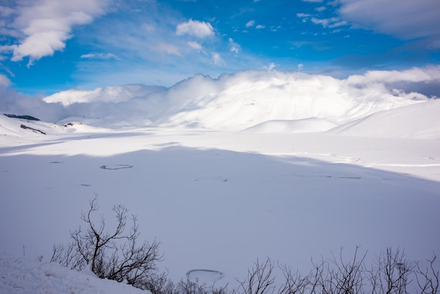 Vale da paisagem de inverno e colinas cobertas de neve em um dia ensolarado