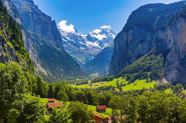 Vale Lauterbrunnen, cachoeira e a parede Lauterbrunnen nos Alpes suíços, Suíça. Montanhas Eiger, Monch e Jungfrau ao fundo.