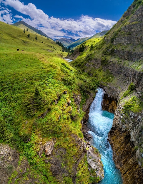 Vale montanhoso com rio e cachoeira, vista aérea