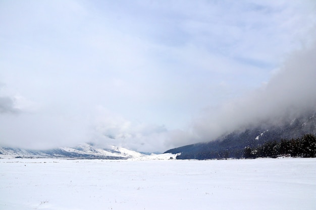 Vale nevado entre as montanhas do Cáucaso coberto por nuvens