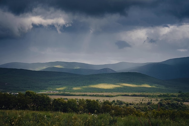 Vale verde pitoresco entre as montanhas antes de uma tempestade