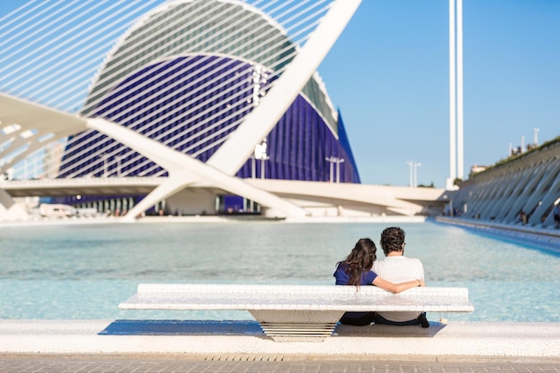 VALENCIA ESPAÑA 18 DE JUNIO DE 2015 Pareja joven se relaja en la piscina con vistas al Oceanografic en la ciudad de las artes y las ciencias en Valencia España