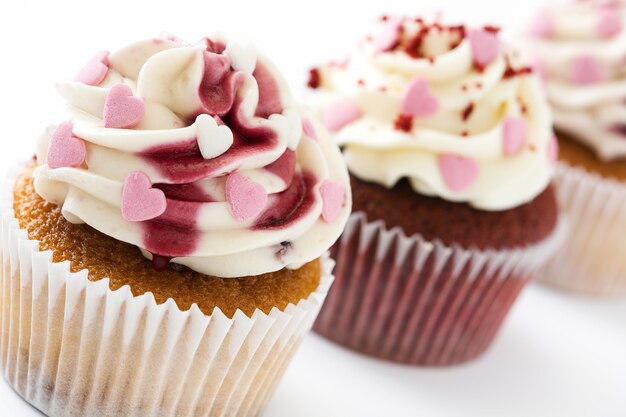 Valentinsgrußkleine kuchen verziert mit Schatzen auf Weiß.