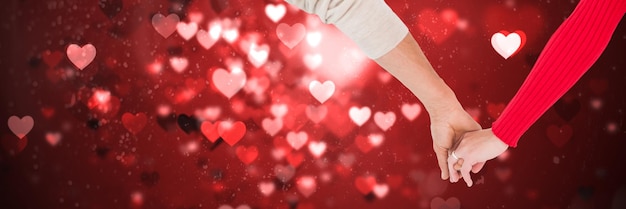 Valentinsgrußpaarhändchenhalten und Liebesherzhintergrund