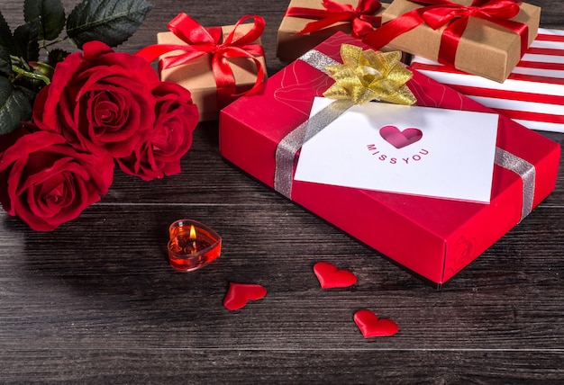 Valentinsgrußtageshintergrund, Valentinsgrußtageskarte mit Rosen und Geschenke auf hölzernem Brett