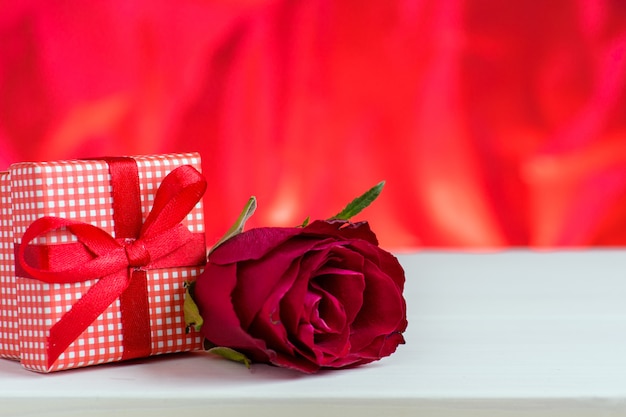 Valentinsgrußtagesroter Hintergrund mit Rosen und Geschenkbox.