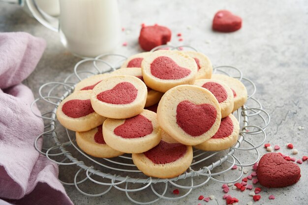 Valentinstag Cookies Shortbread Cookies in einem süßen roten Herzen auf rosa Teller auf grauem Hintergrund Muttertag Womans Day Süße Feiertage backen Draufsicht