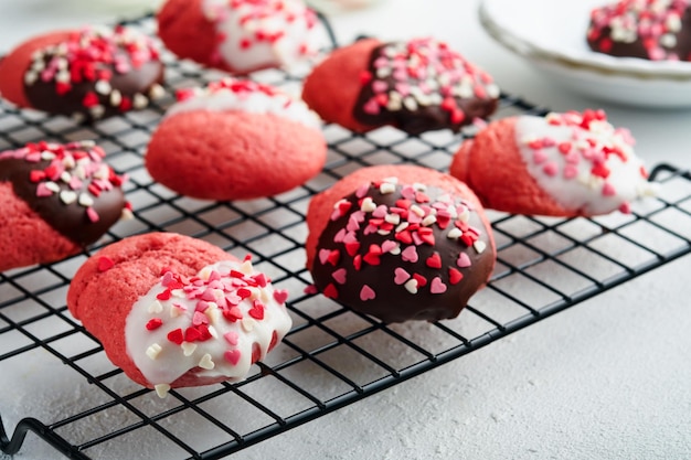 Valentinstag Cookies Shortbread Cookies mit Glasur weiße und dunkle Schokolade und Herz Streuseln auf Platte auf weißem Hintergrund Muttertag Womans Tag Süße Feiertage backen Draufsicht