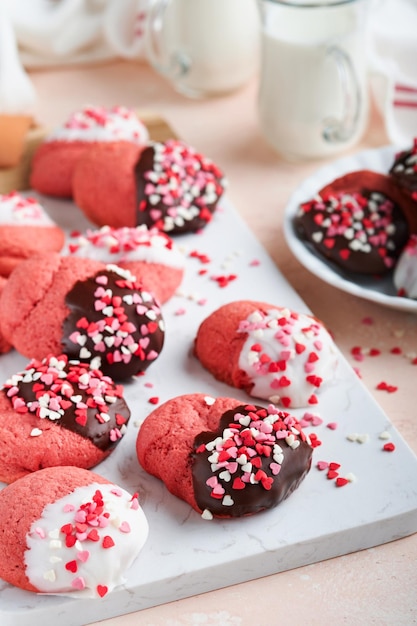 Valentinstag Cookies Shortbread Cookies mit Glasur weiße und dunkle Schokolade und Herz Streuseln auf Platte auf weißem Hintergrund Muttertag Womans Tag Süße Feiertage backen Draufsicht