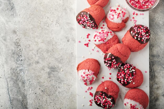 Valentinstag Cookies Shortbread Cookies mit Glasur weiße und dunkle Schokolade und Herz Streuseln auf Platte auf weißem Hintergrund Muttertag Womans Tag Süße Feiertage backen Draufsicht