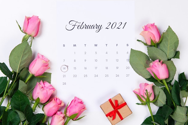 Valentinstag Februar Kalender, Diamantring, Geschenk und rosa Rosen auf weißem Hintergrund.