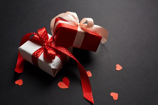 Valentinstag Geschenkboxen mit roten Herzen auf schwarzem Papierhintergrund