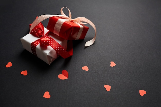 Valentinstag Geschenkboxen mit roten Herzen auf schwarzem Papierhintergrund